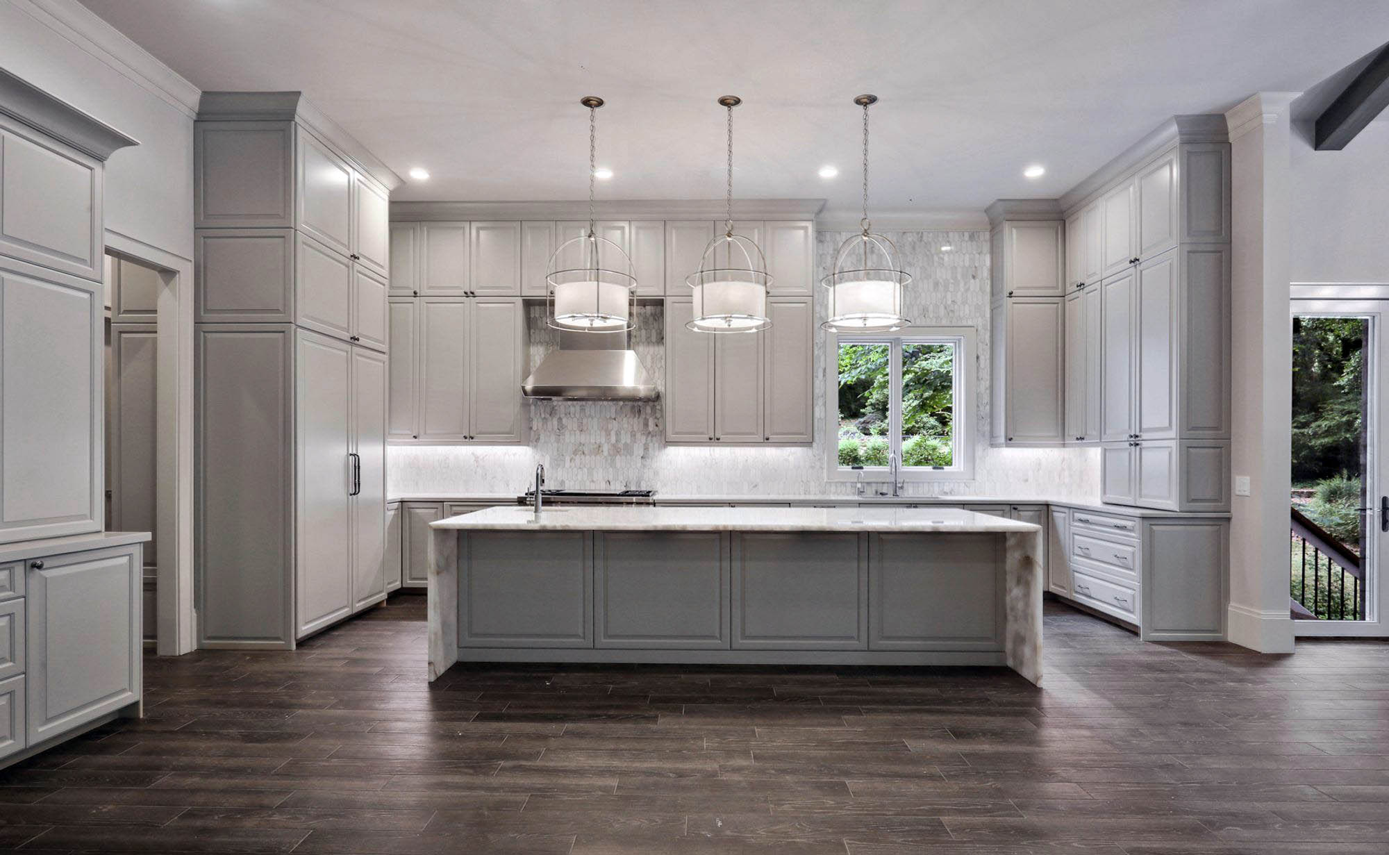 Gray tile wood floors with gray cabinets and marble countertops.