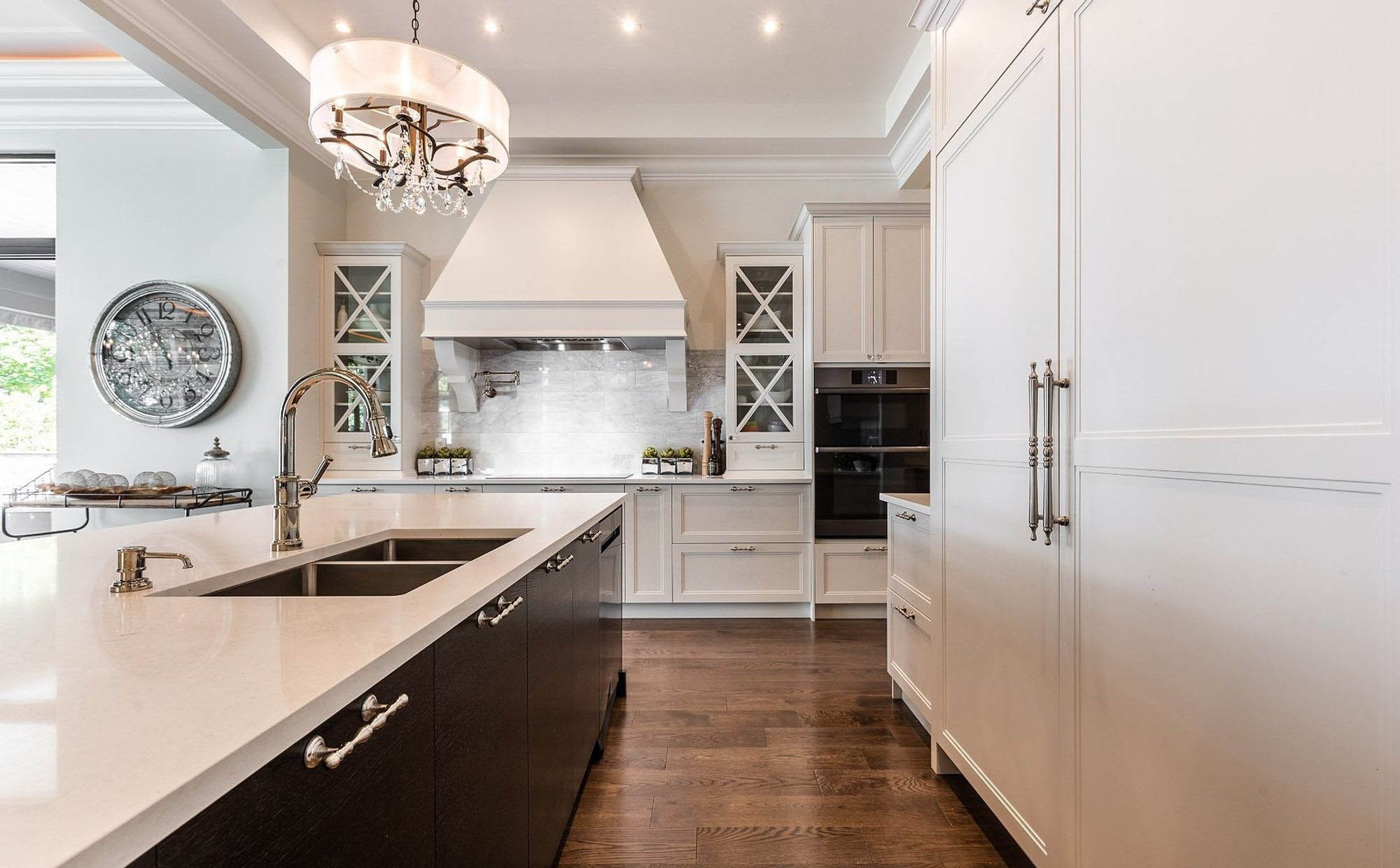 Fake wood oak tile flooring in this beautiful luxury kitchen. White cabinets with a dark brown island.
