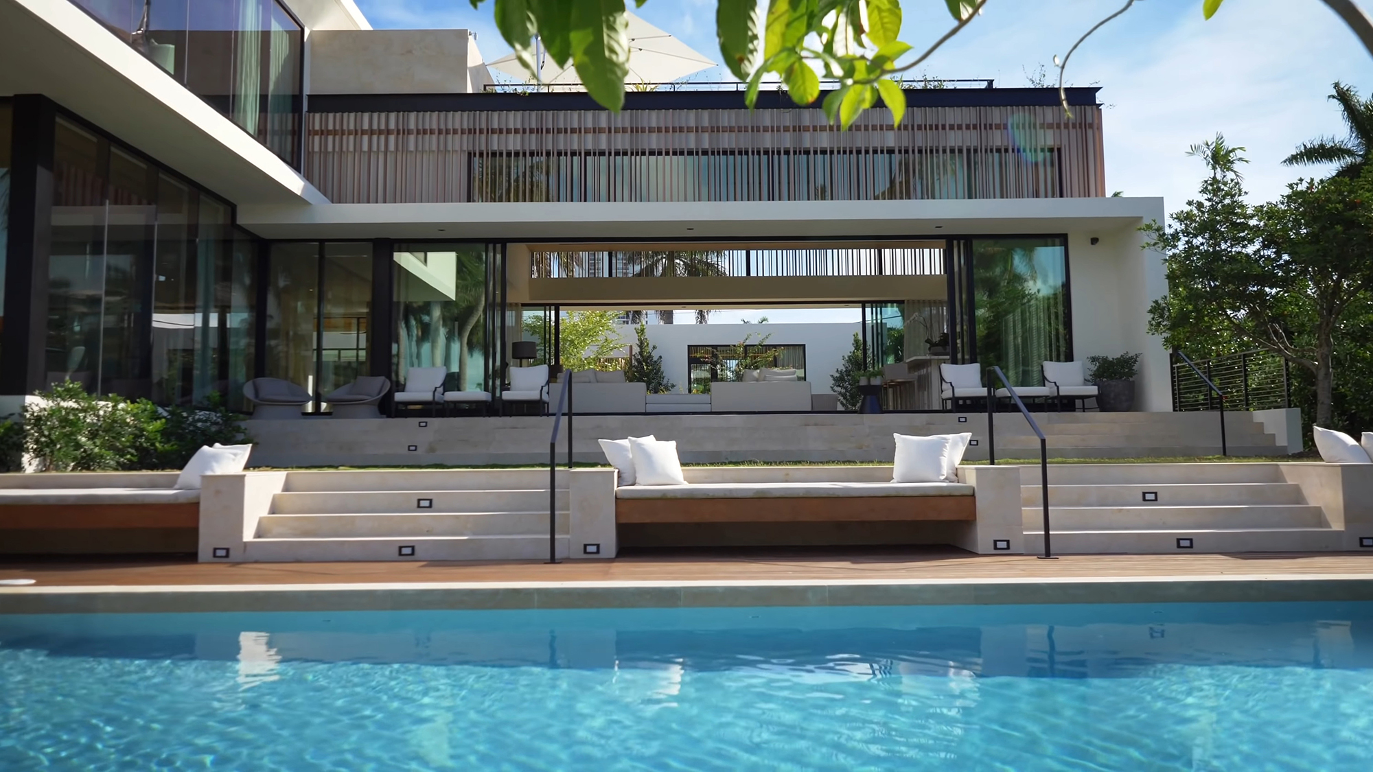 Poolside view of this contemporary home with flat rooftop decks and built in planters.