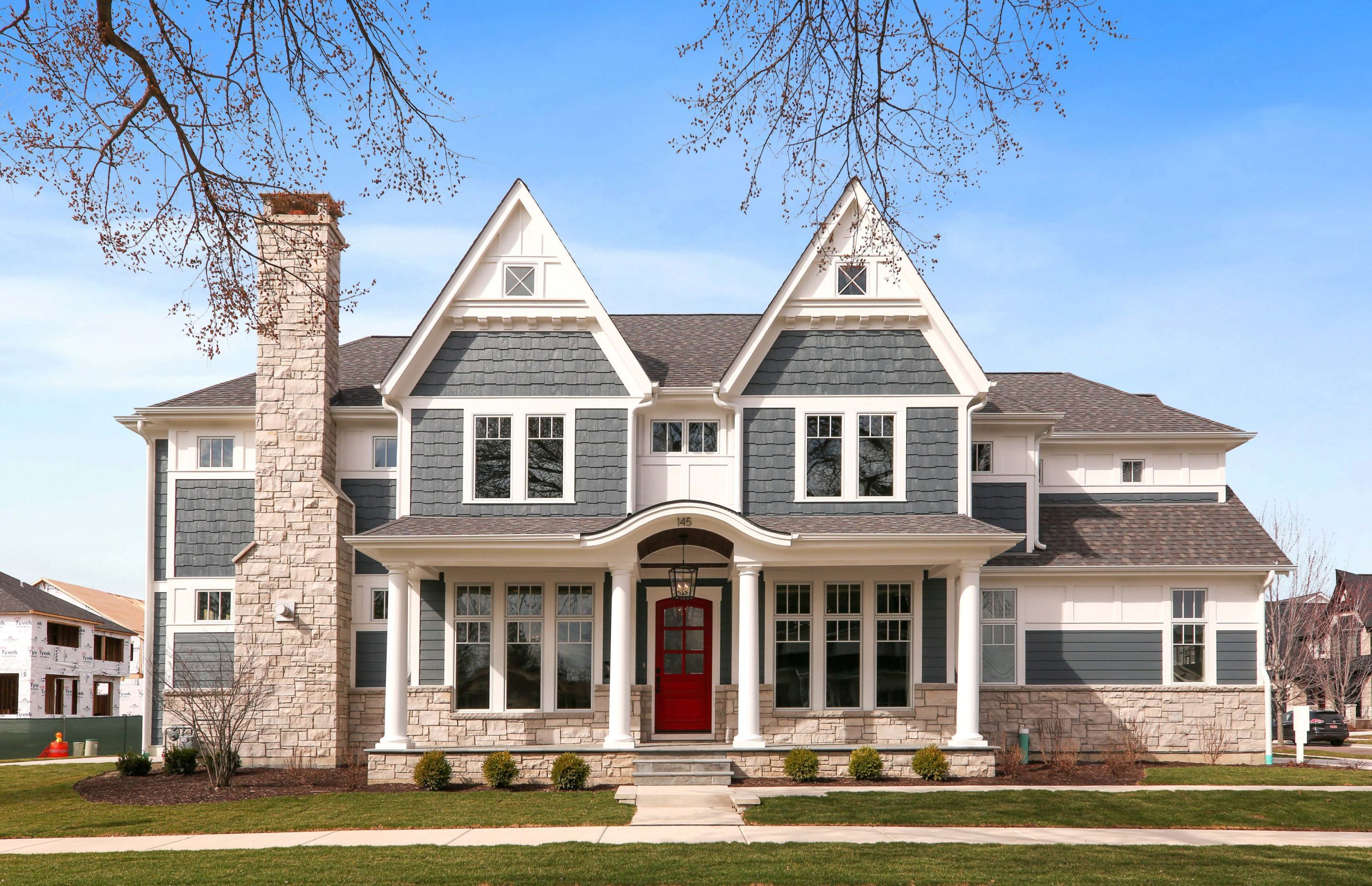 Classic red, white and blue house color scheme. Gray blue cedar shake siding with white trim and a bright red front door.