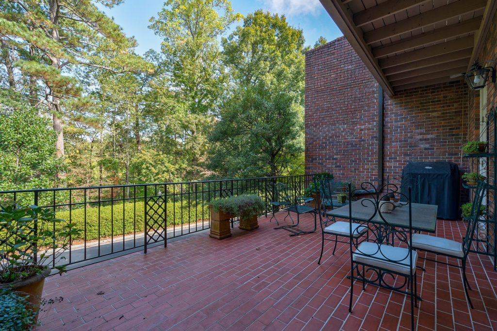 Red brick home with a brick rear patio. 