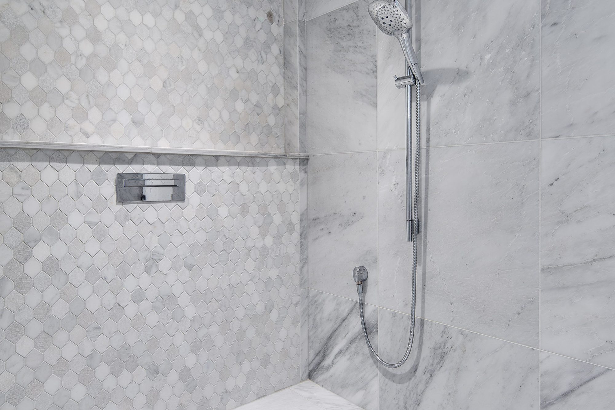 Marble tile shower with sanded white grout.