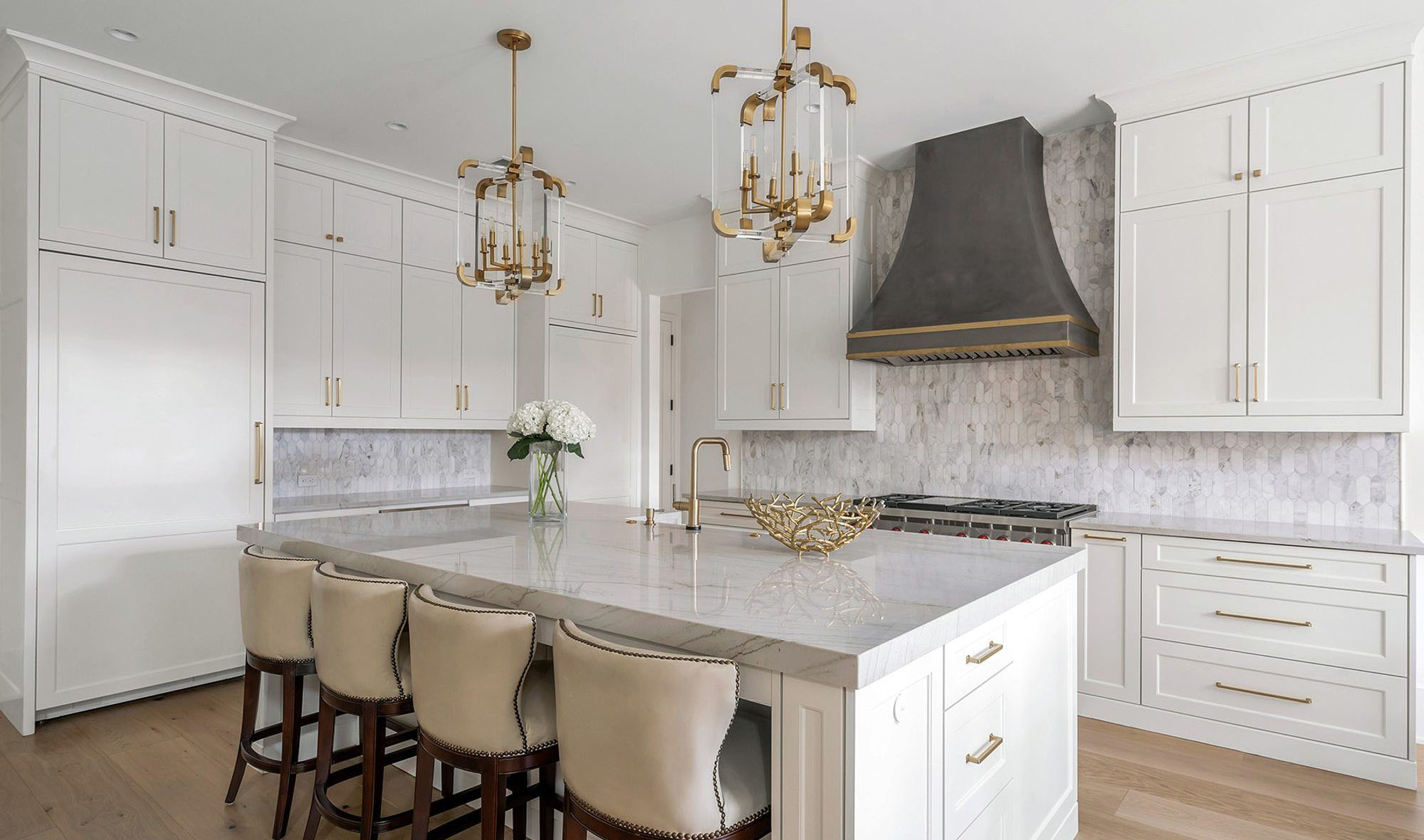 Elegant white and gray kitchen with marble tile backsplash, marble countertops, white cabinets and medium gray grout.