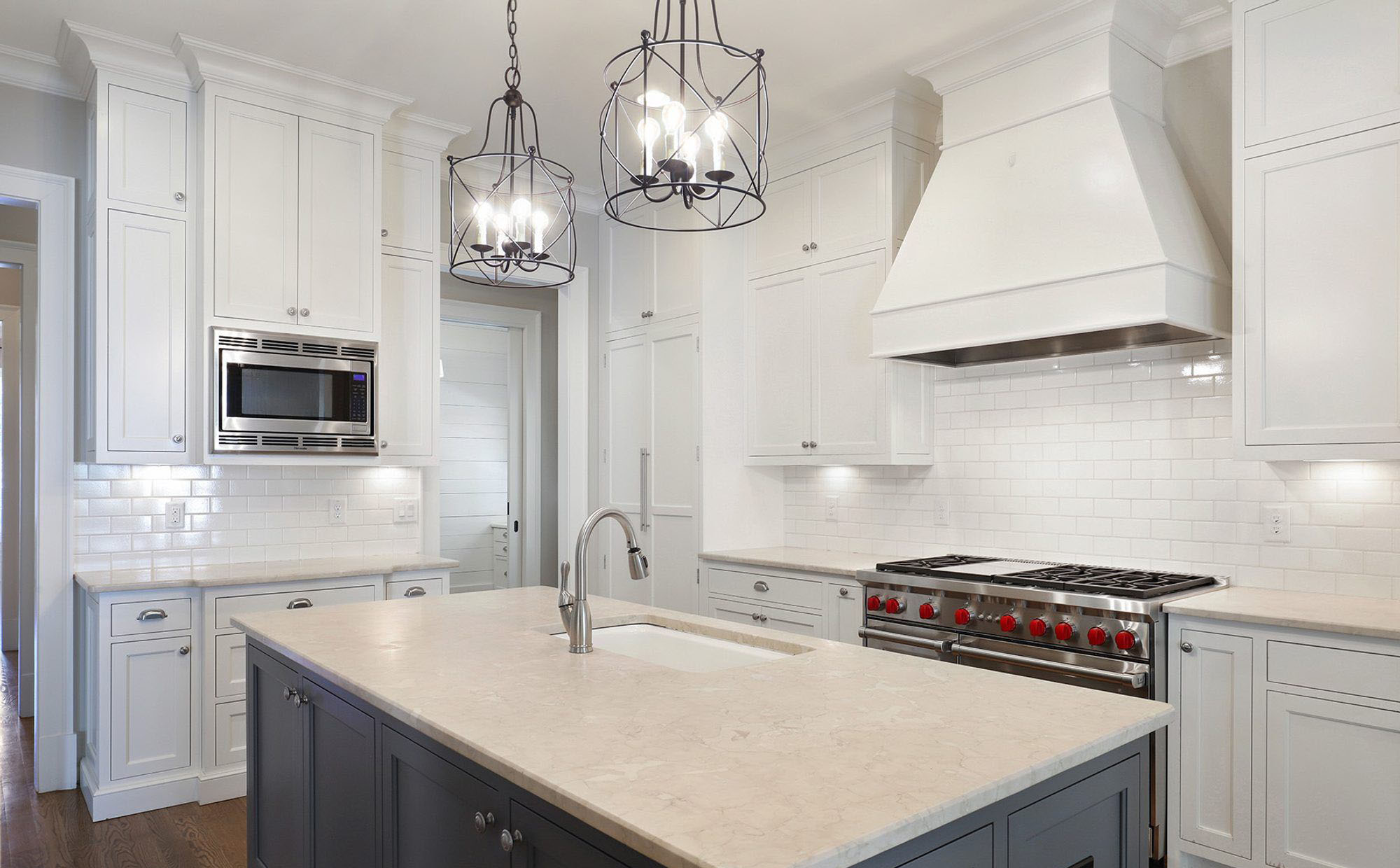 This medium gray island is a nice choice along side the white shaker style cabinetry. two tone kitchen cabinets.