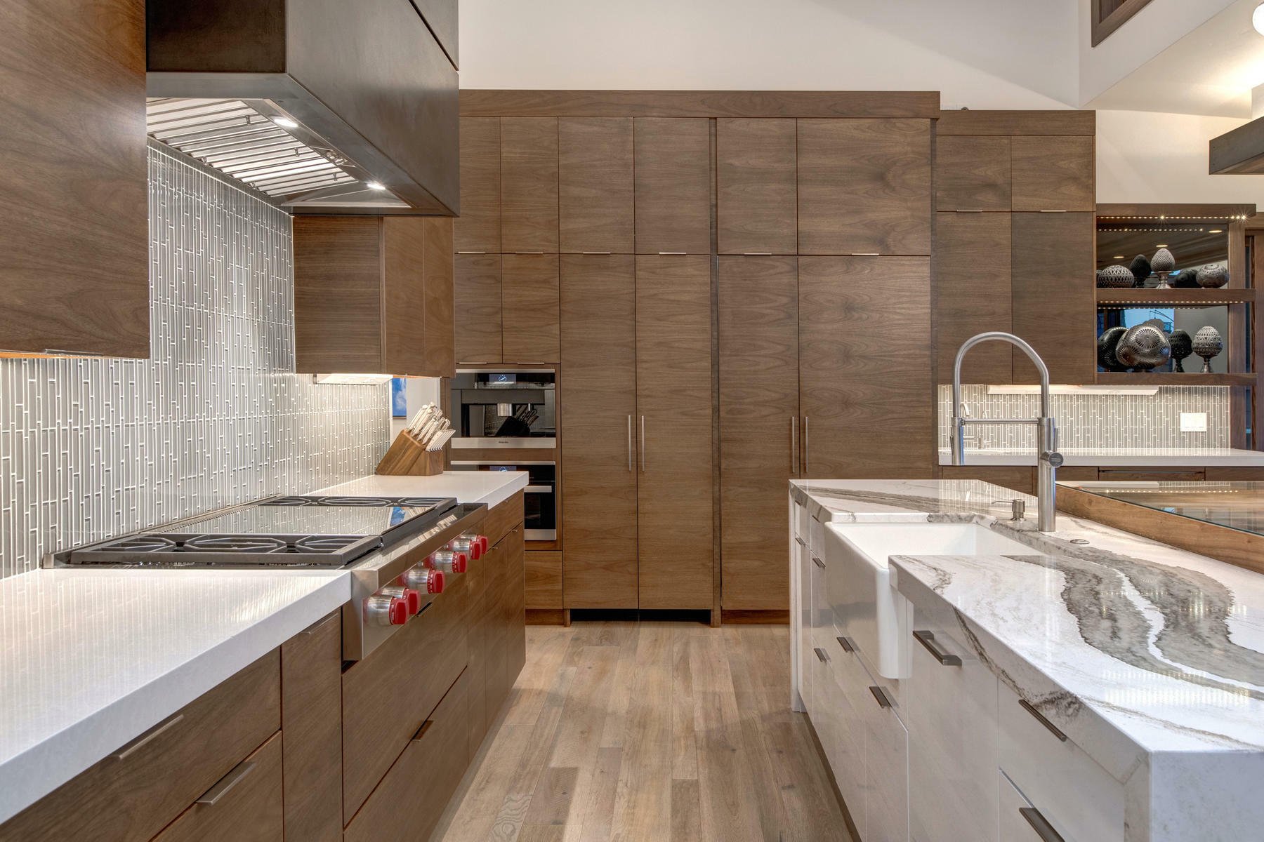Modern kitchen with two cabinet colors. Medium brown wood with white.