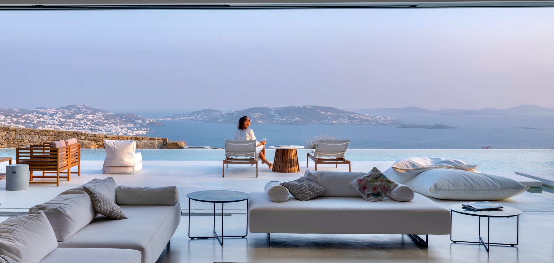 Modern Greek Home Mykonos. View from inside the home overlooking the infinity edge pool and Greece. 