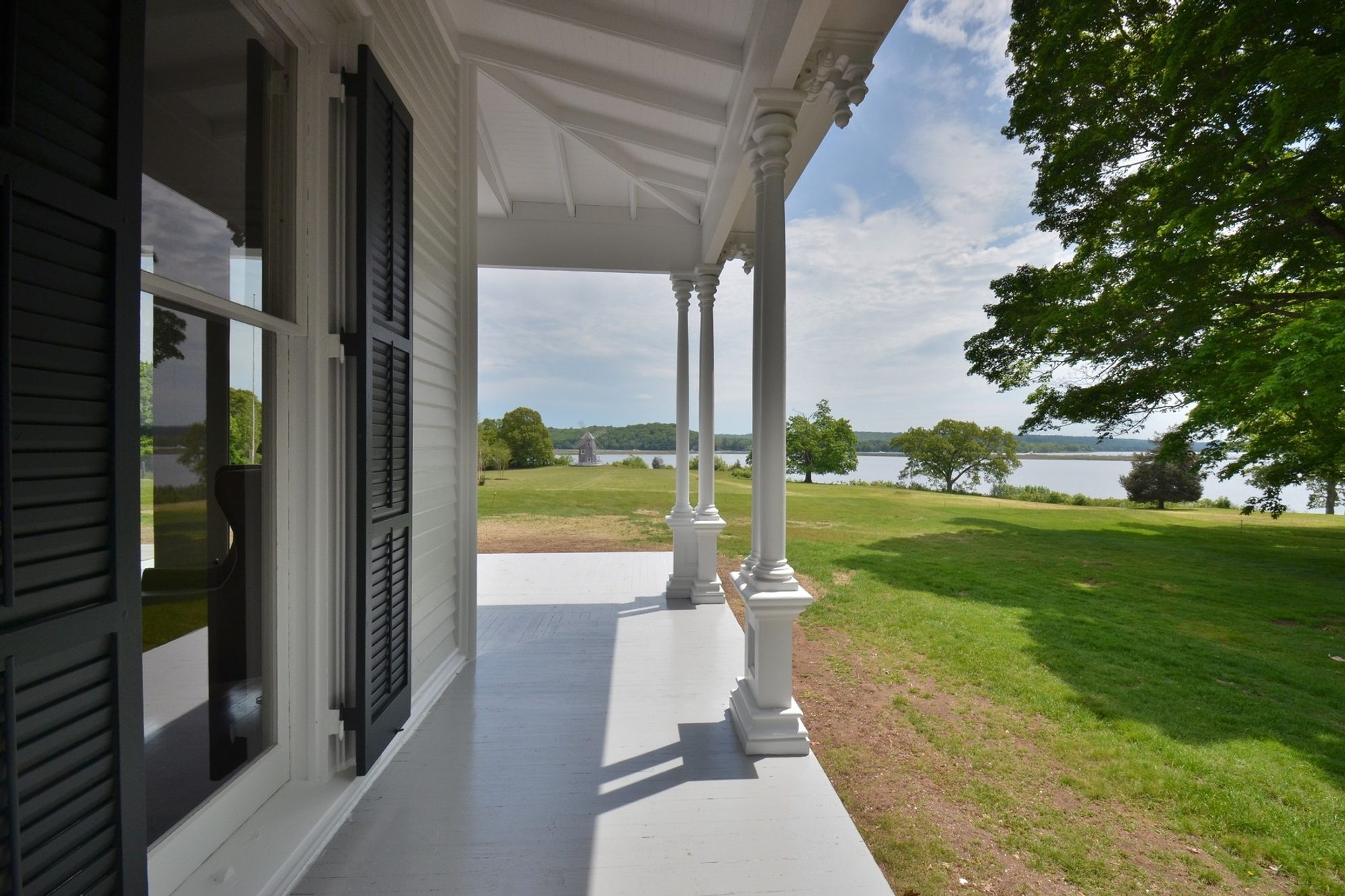 Covered front porch with wood flooring painted solid gray. porch flooring ideas. 