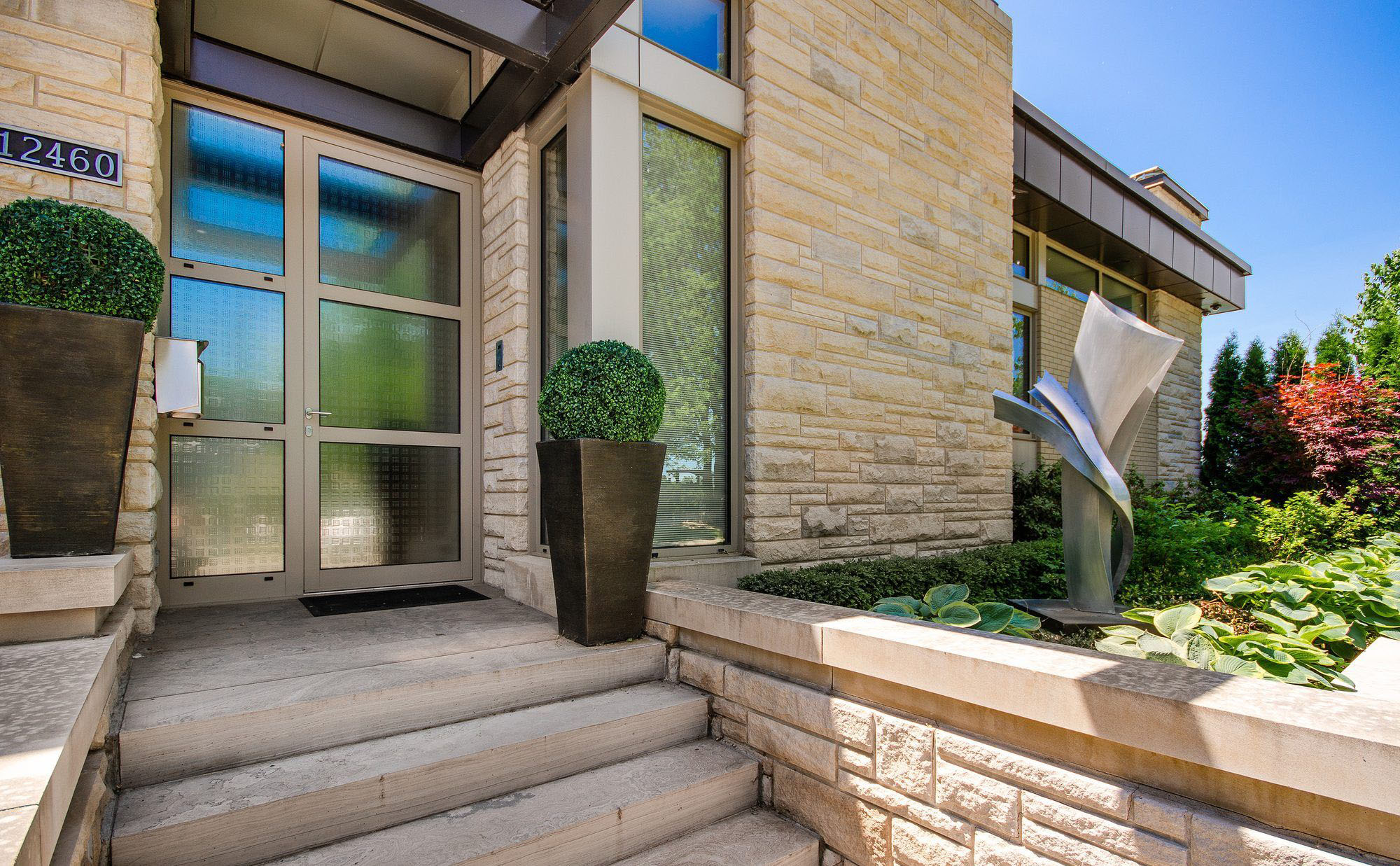 Modern home with a textured concrete front porch and matching steps. stamped concrete walls. 