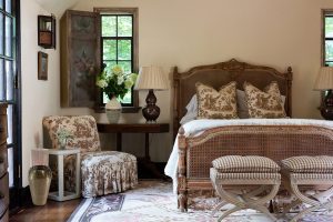 bohemian style bedroom with a brown, tan and cream color scheme. Wicker. Prints. Antique.