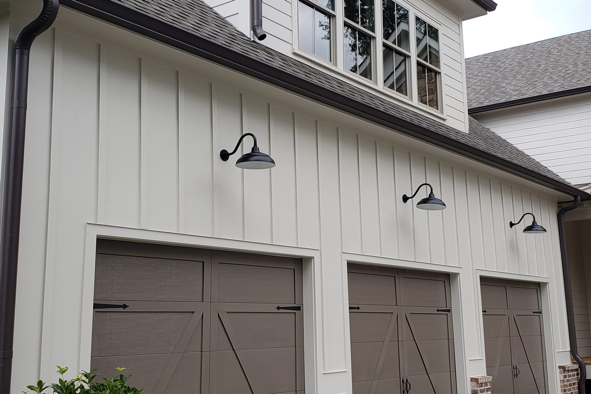 beautiful medium grey doors on a light grey house with vertical board and batten siding. 