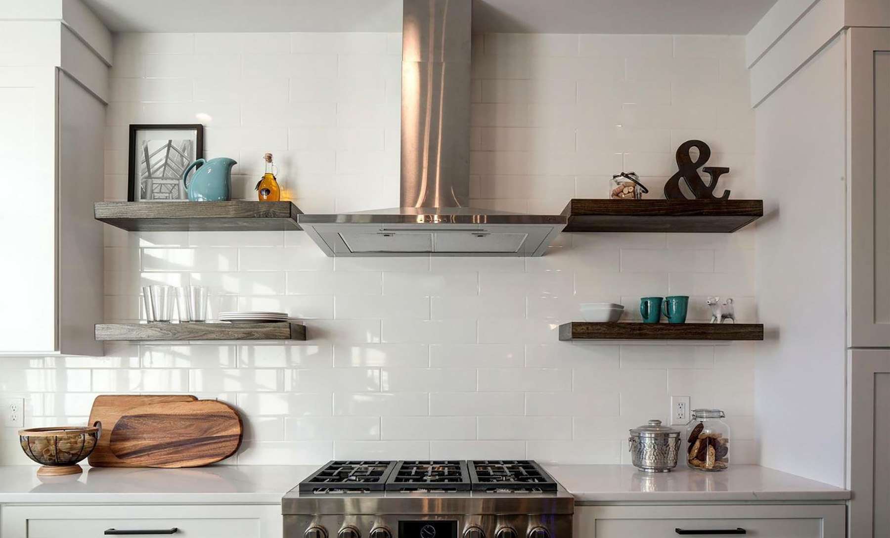 Painted white kitchen cabinets with subway tile backsplash and floating wood shelves.
