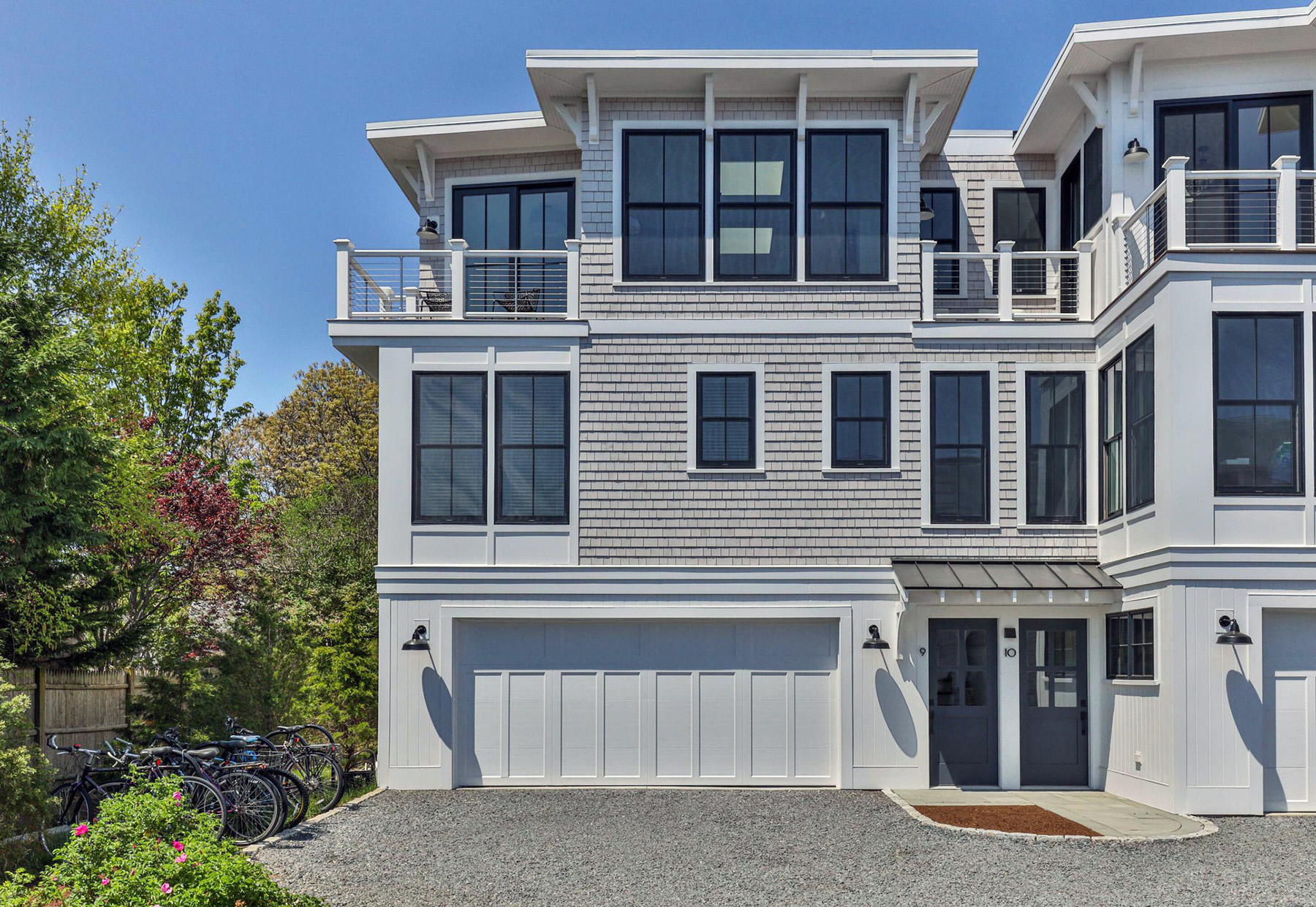 Beautiful design featuring light gray shake siding with white trim and black windows. Lots of Azek work.