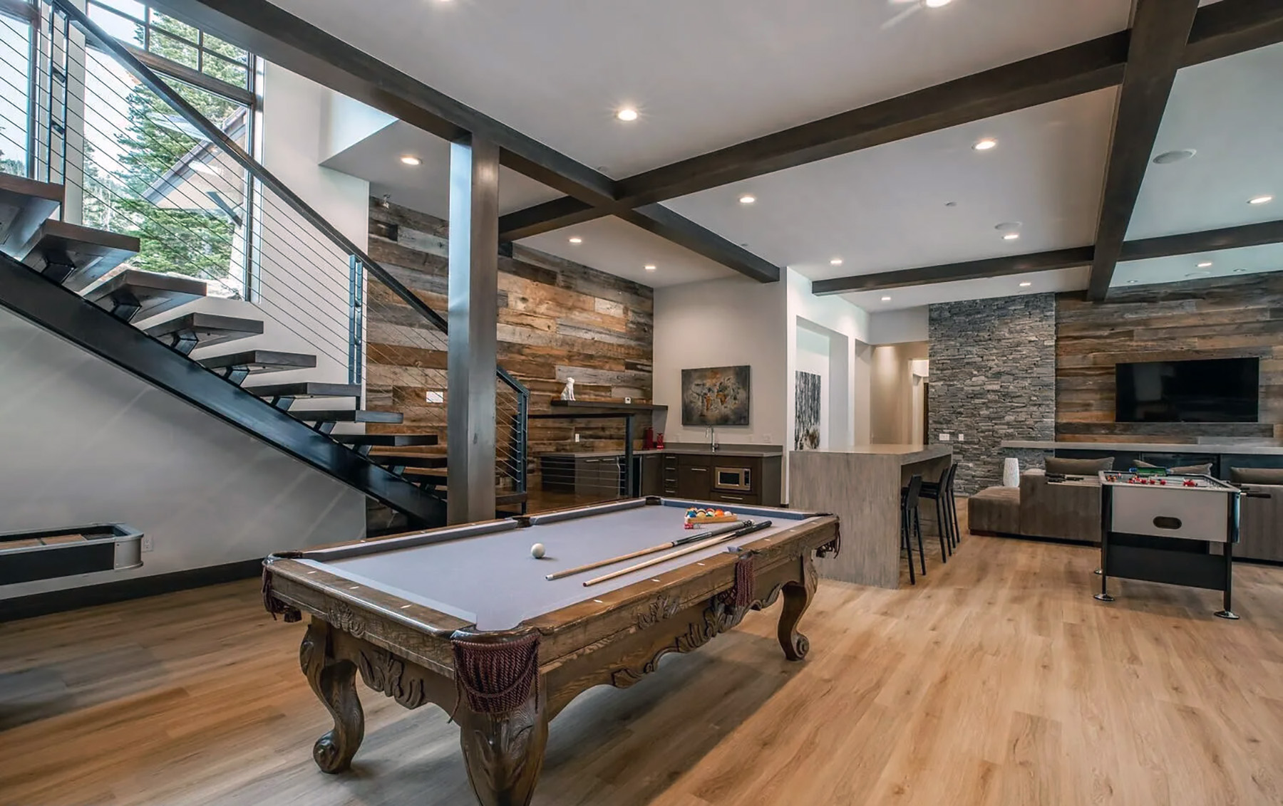 Ornate wood pool tables with gray felt.