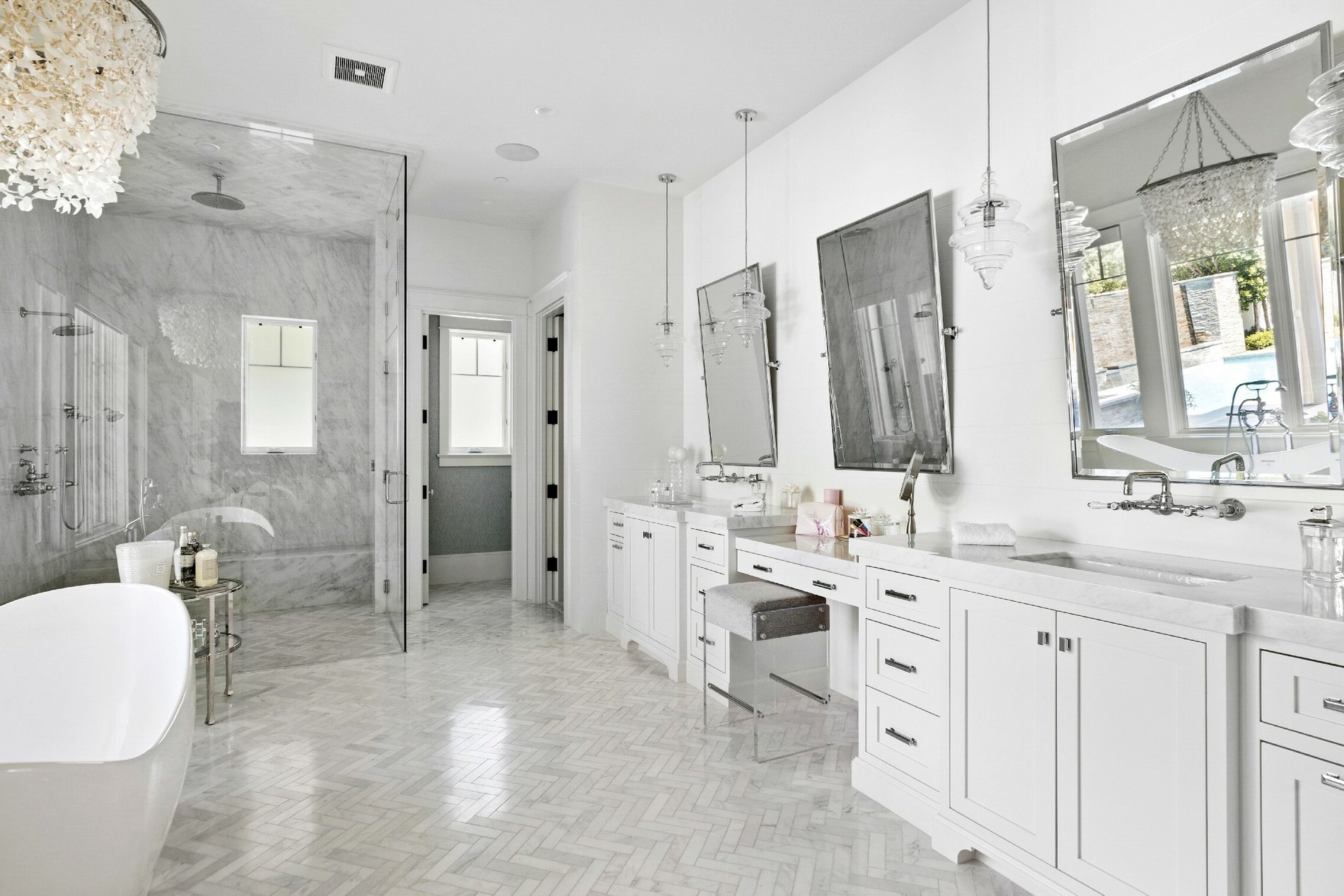 Roll-in shower in a beautiful all white and marble bathroom.