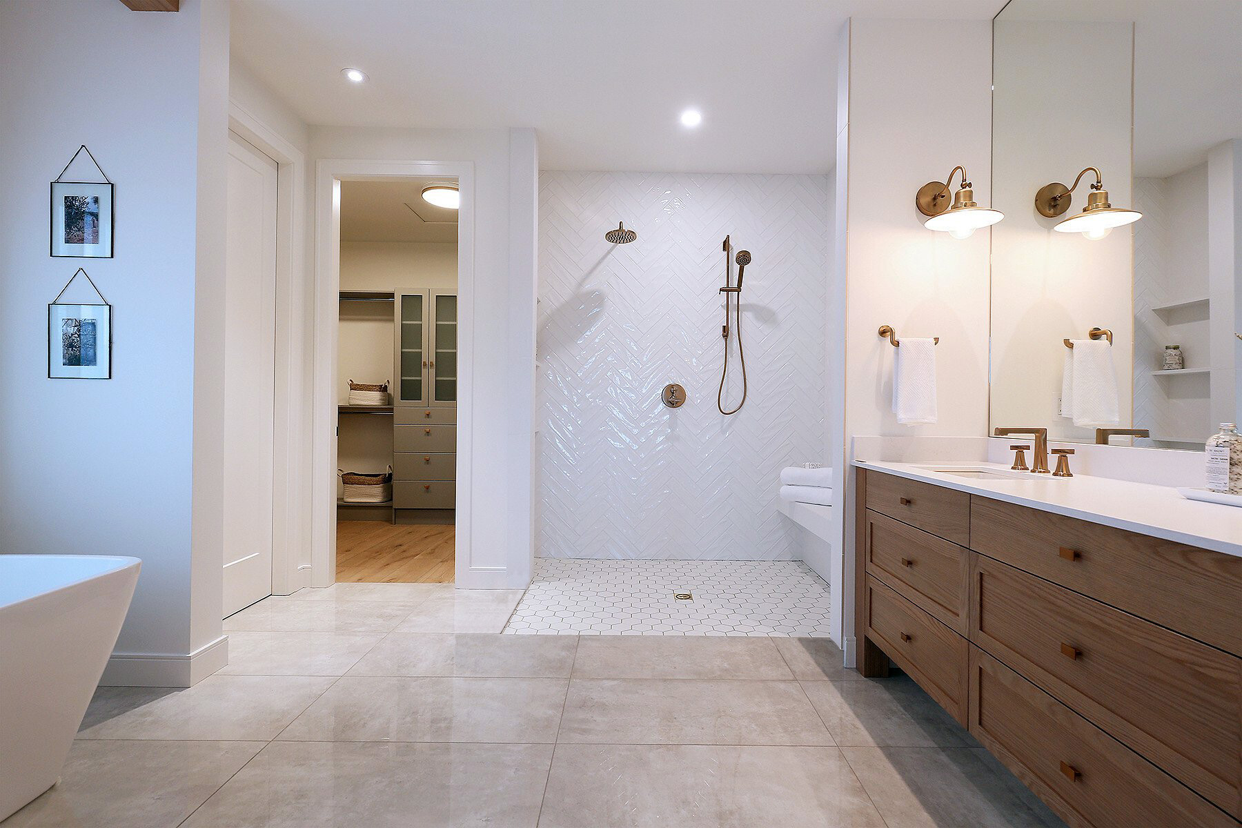 Roll in shower with white porcelain tiles, bench seating and multiple shower heads.