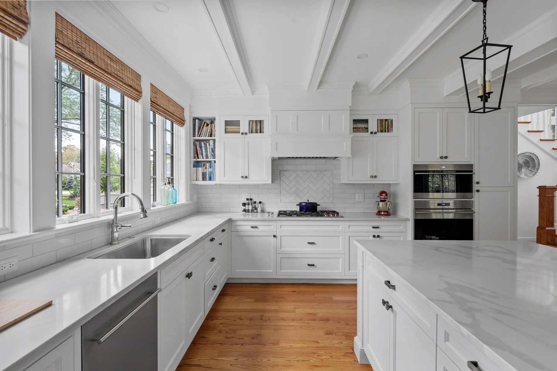Beautiful all white kitchen with large island. Quartz countertops. Marble backsplash.