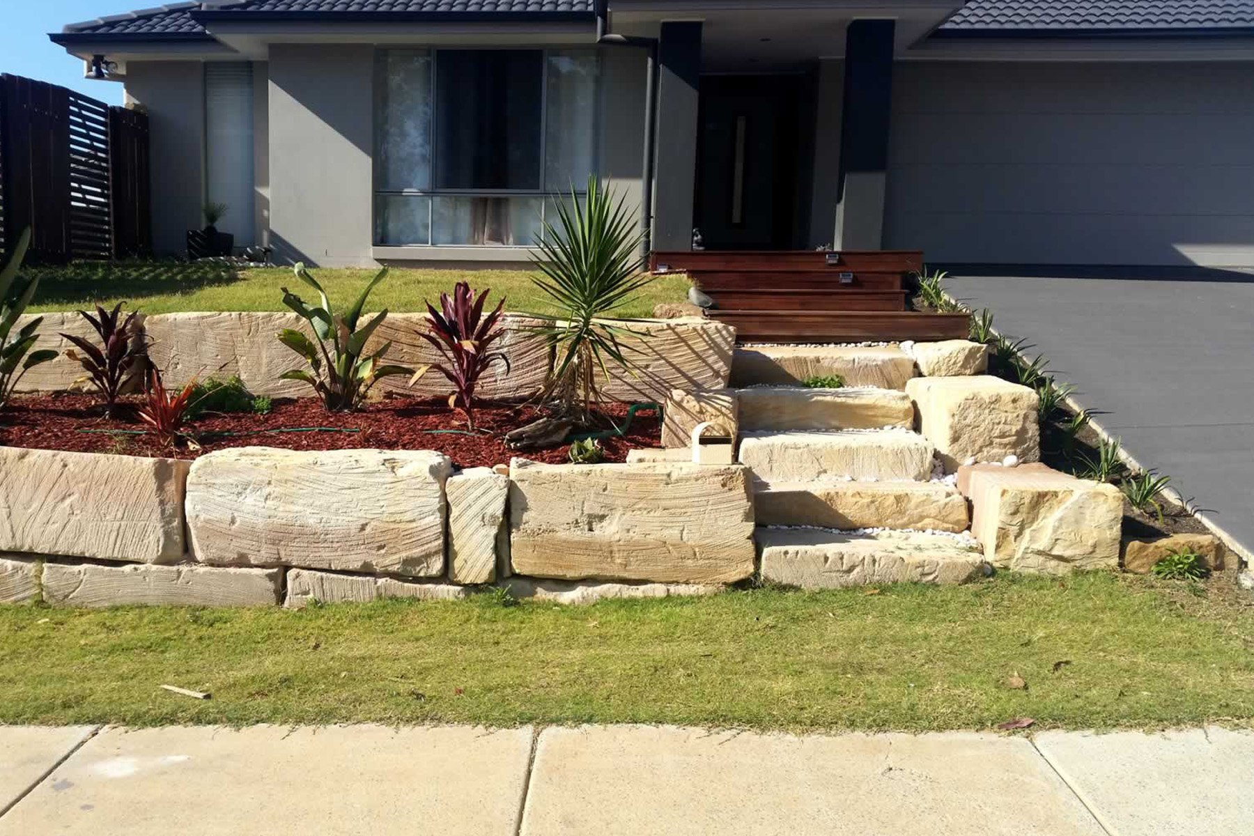 large stone retaining wall with planter bed & stone steps