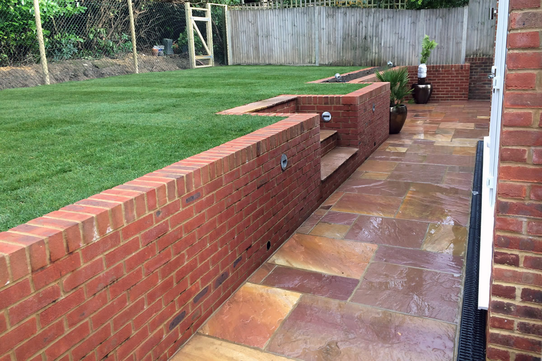red brick retaining wall with stone tile walkway and steps