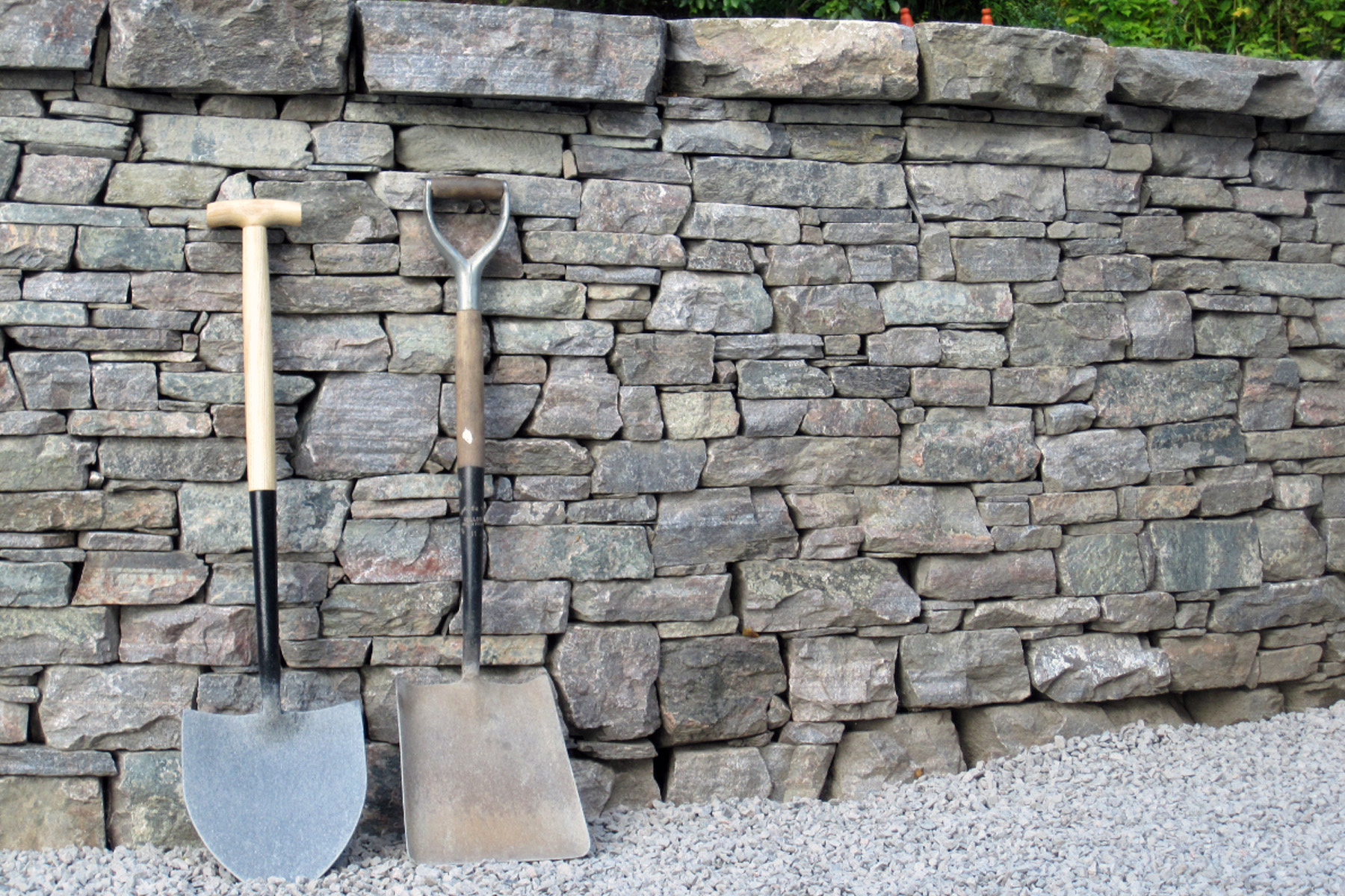 medium sized stacked real stone retaining wall with stone cap