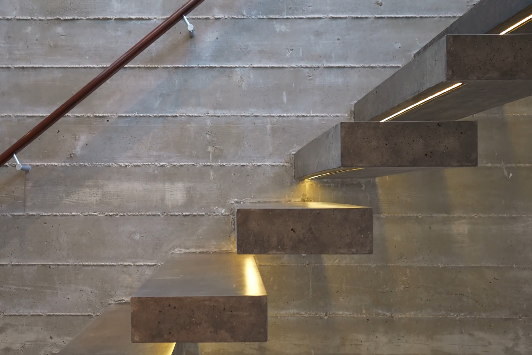 board from concrete walls with concrete steps and hidden lighting