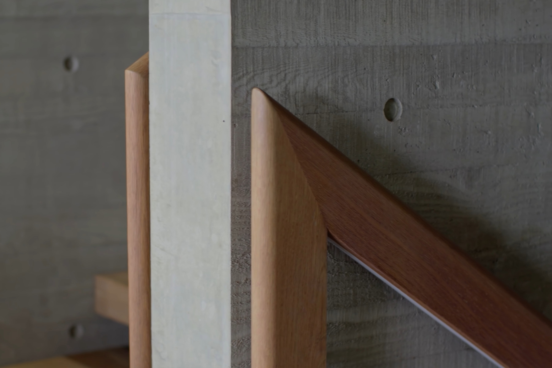 poured concrete wall closeup pic with wood handrail