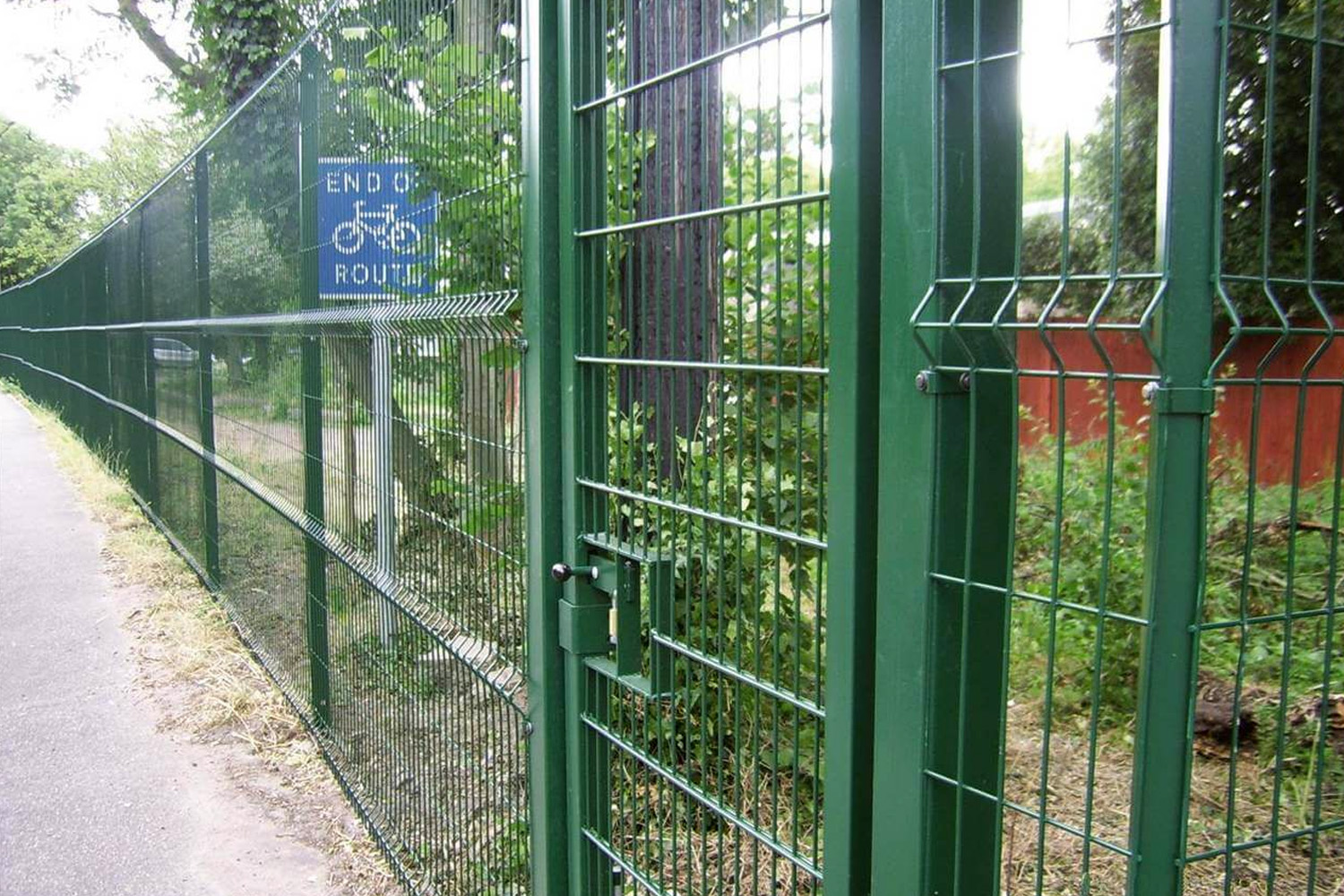 green welded wire fence with metal posts and brackets and gate