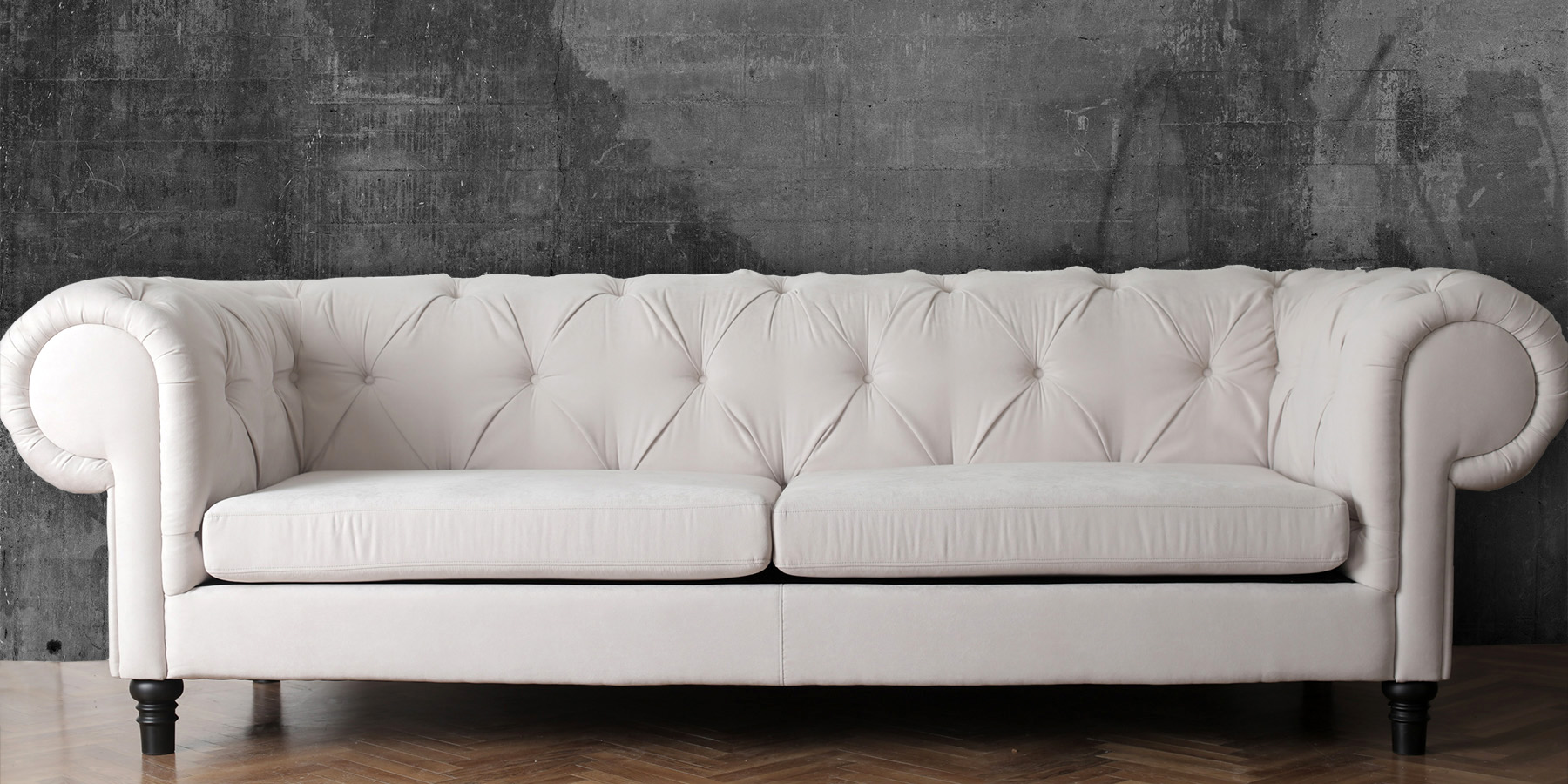 white sofa against a concrete wall 1
