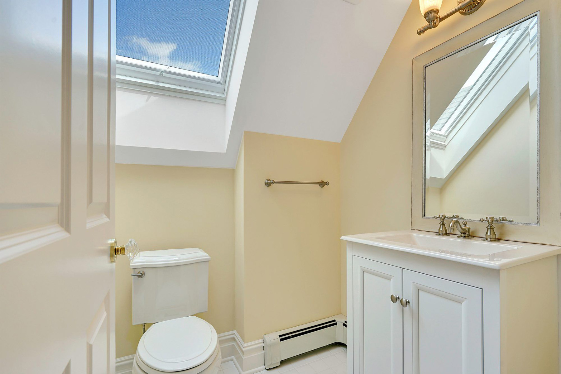 beatiful small bathroom with door opening in including skylight