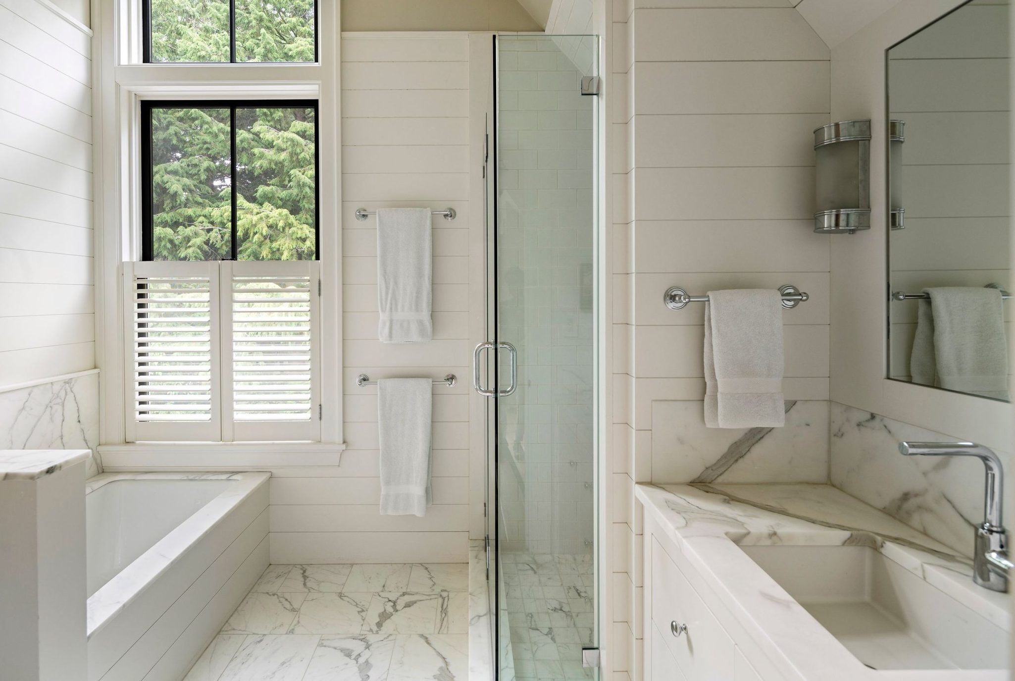 farmhouse bathroom with white shiplap, black frame windows, marble floors